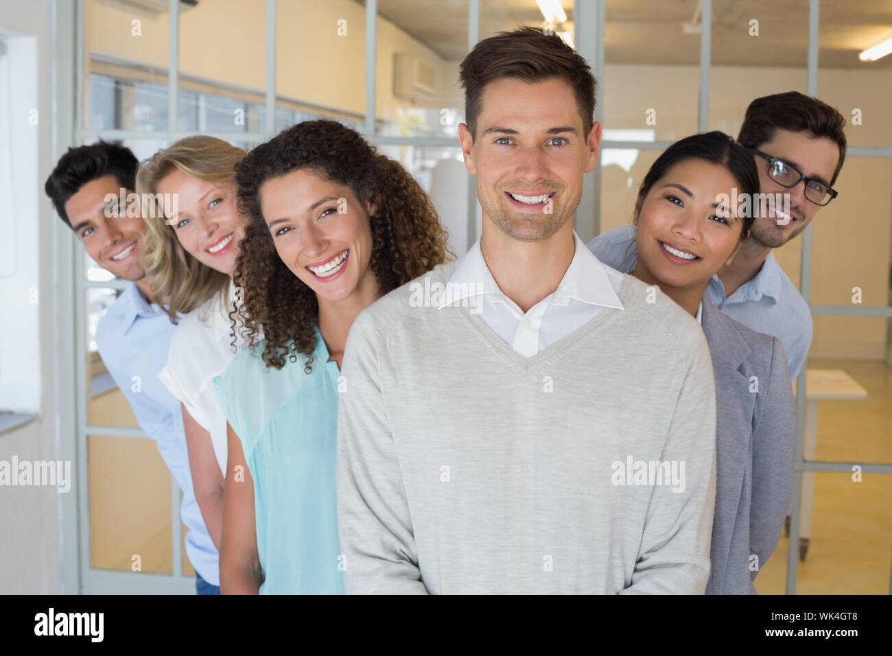 Casual business team smiling at camera together in the office Stock ...