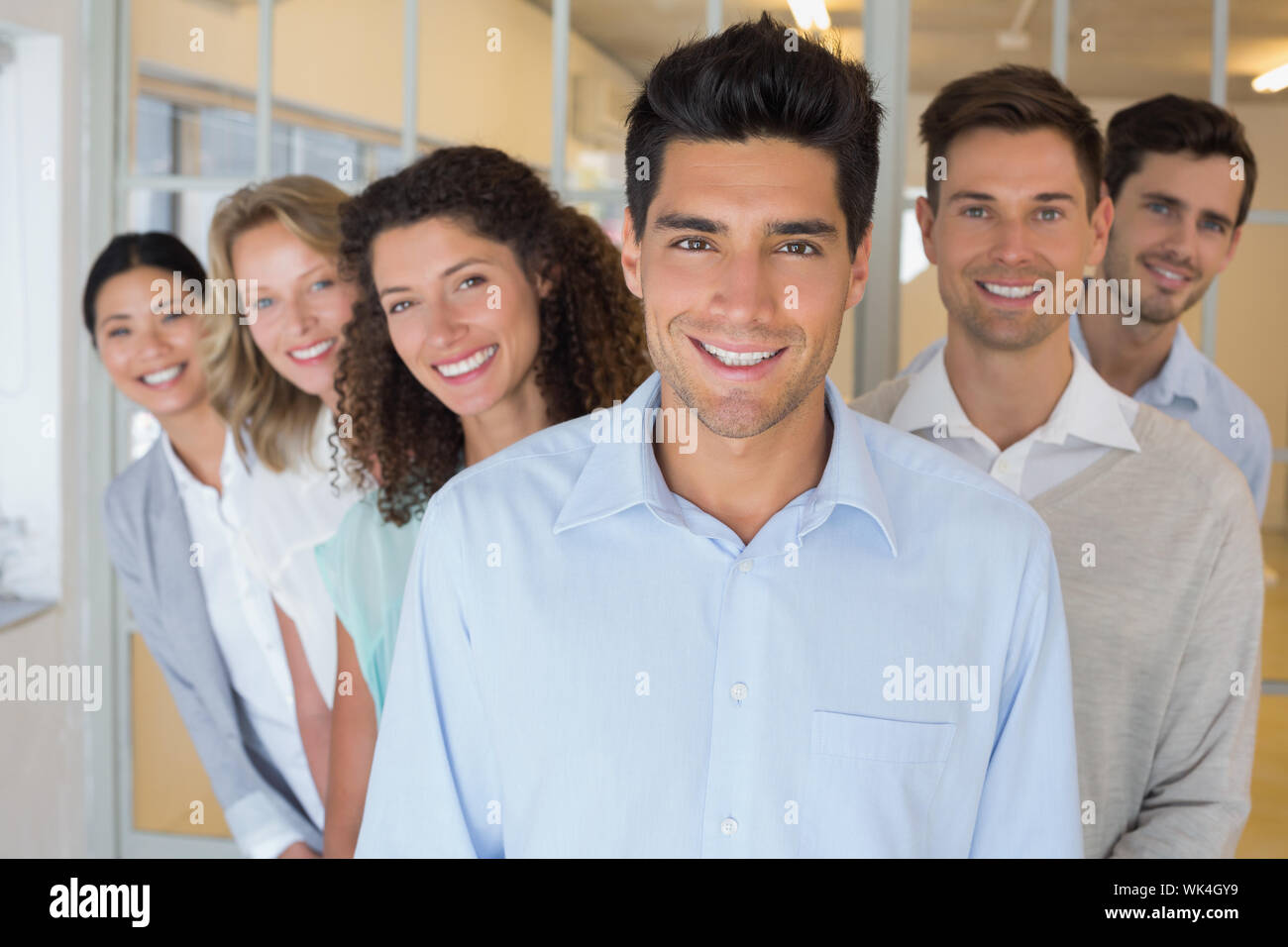 Casual business team smiling at camera together in the office Stock ...