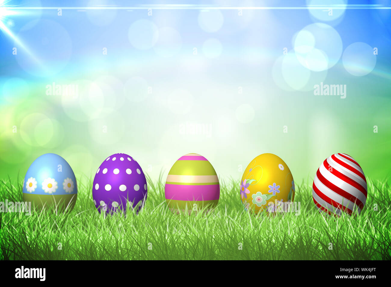 Colourful easter eggs on the grass under sunny sky Stock Photo