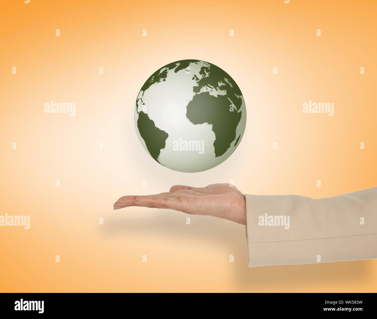 Female hand presenting earth against orange vignette Stock Photo