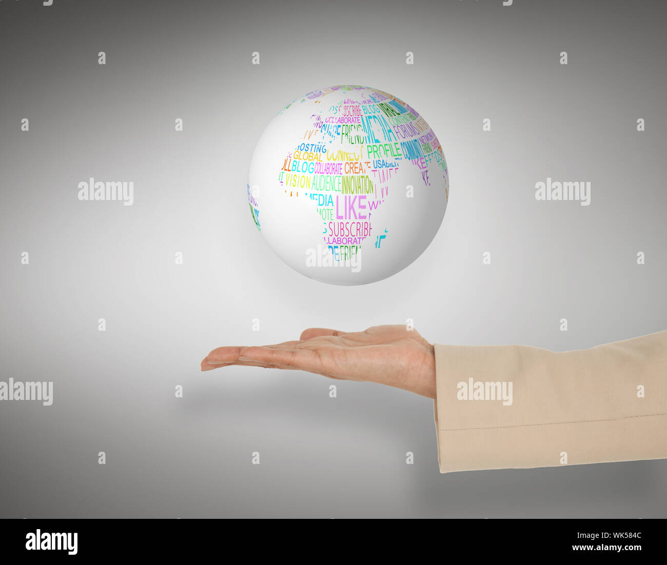 Female hand presenting globe against grey vignette Stock Photo