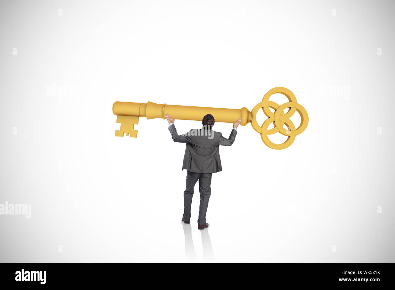Businessman carrying large key with arms raised against white ...