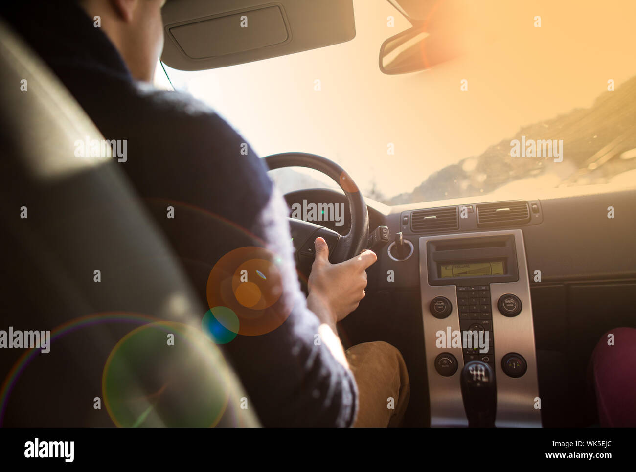 Young man driving his car in a strong sunlight (color toned image Stock ...