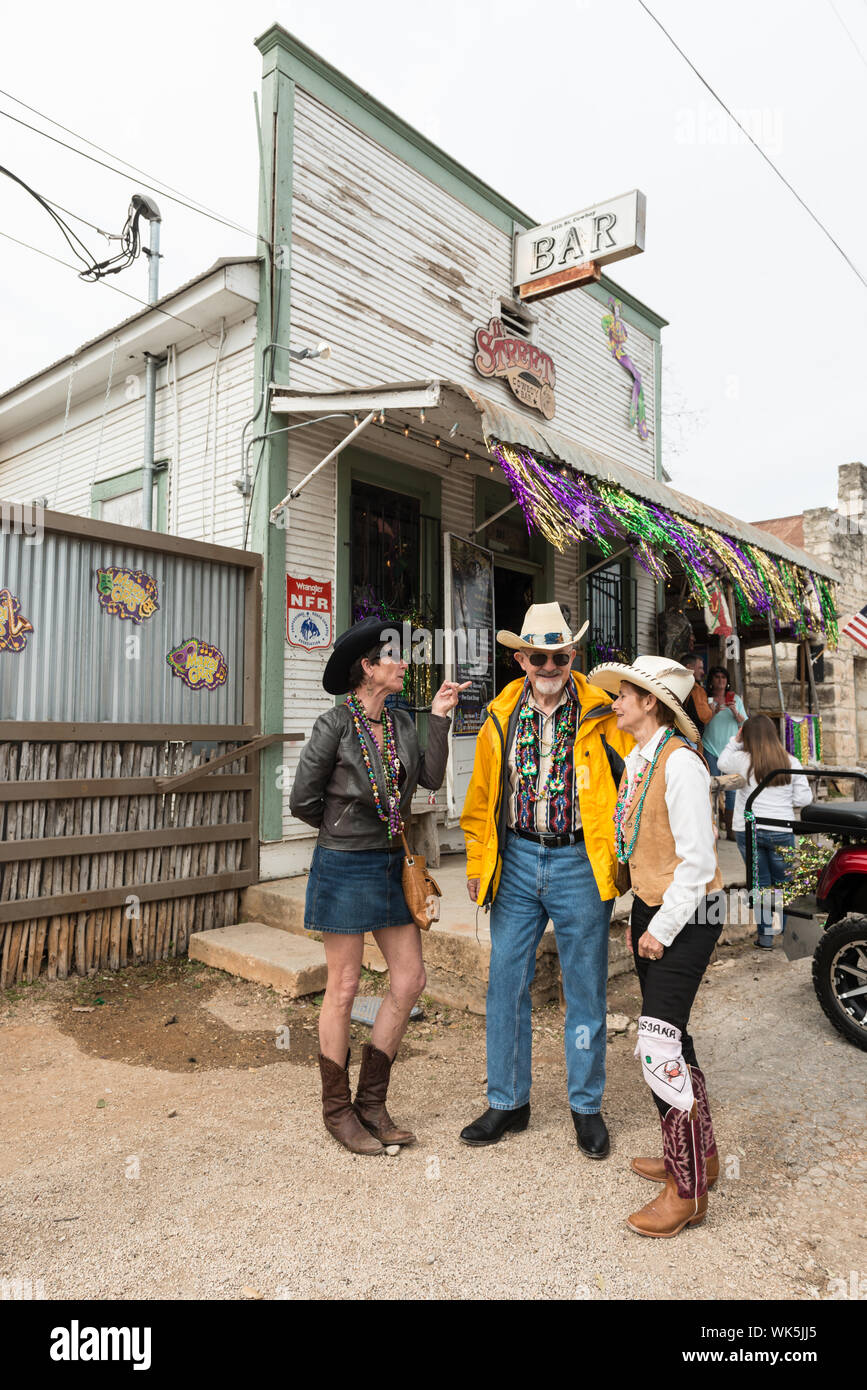 It's cowboy hats and beads for Mardi Gras, a Cowboy Mardi Gras, for Cheryl  Pittman, David Cross, and Marcia Cross outside the 11th Street Bar in  little Bandera, the Cowboy Capital of