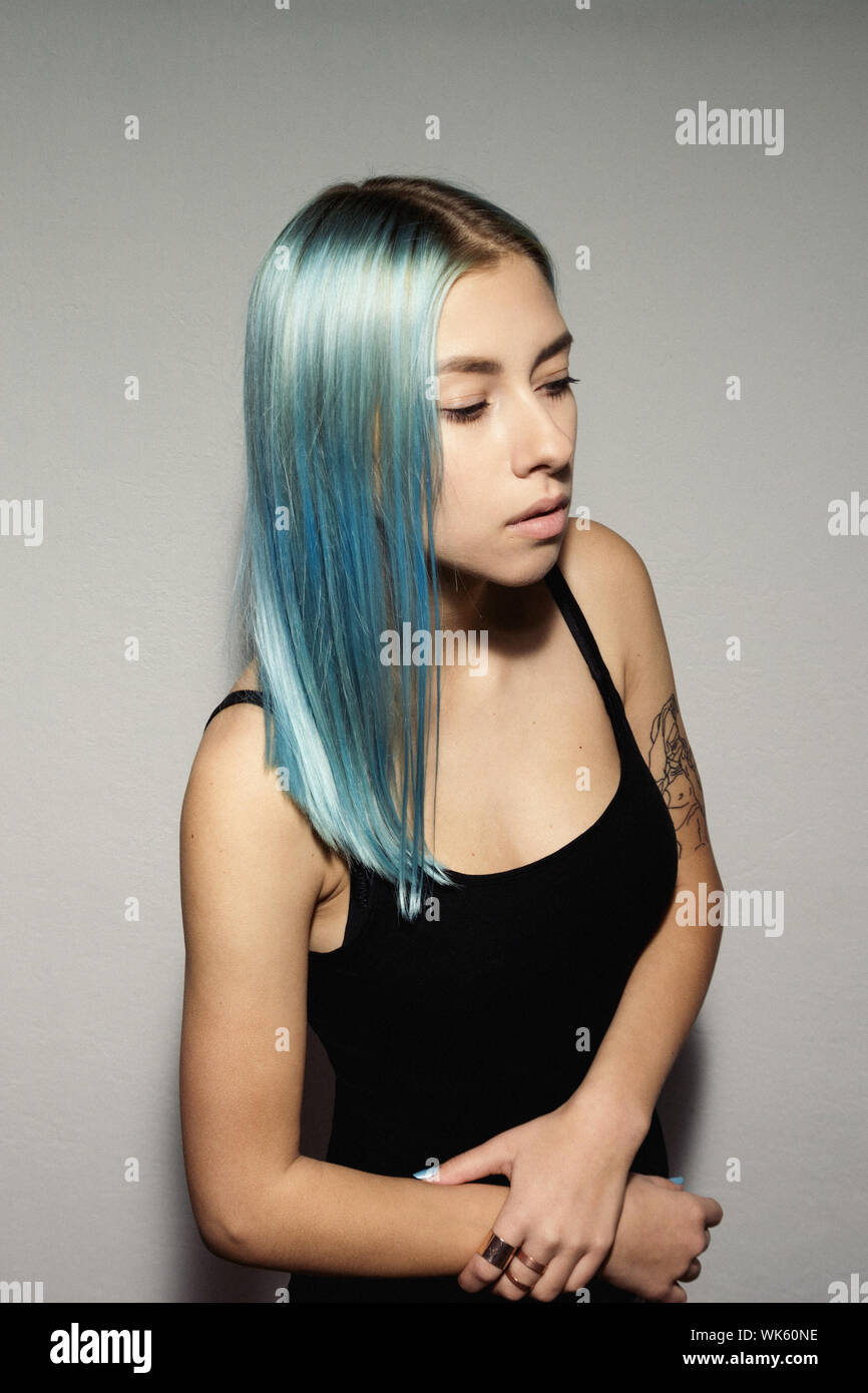 Young Woman With Dyed Hair Standing Against Patterned Wall Stock Photo -  Alamy