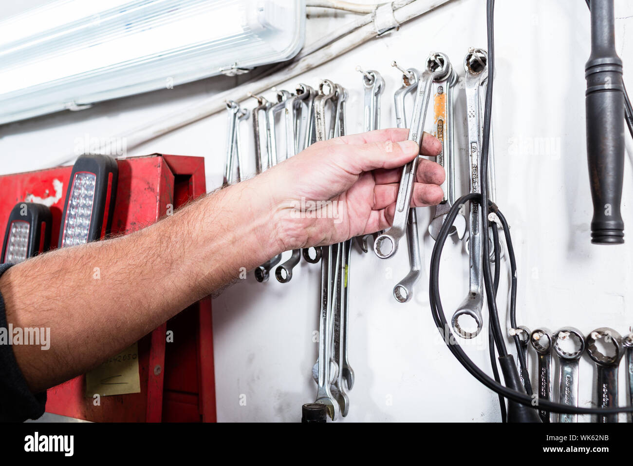Auto mechanic taking spanner from the wall Stock Photo Alamy