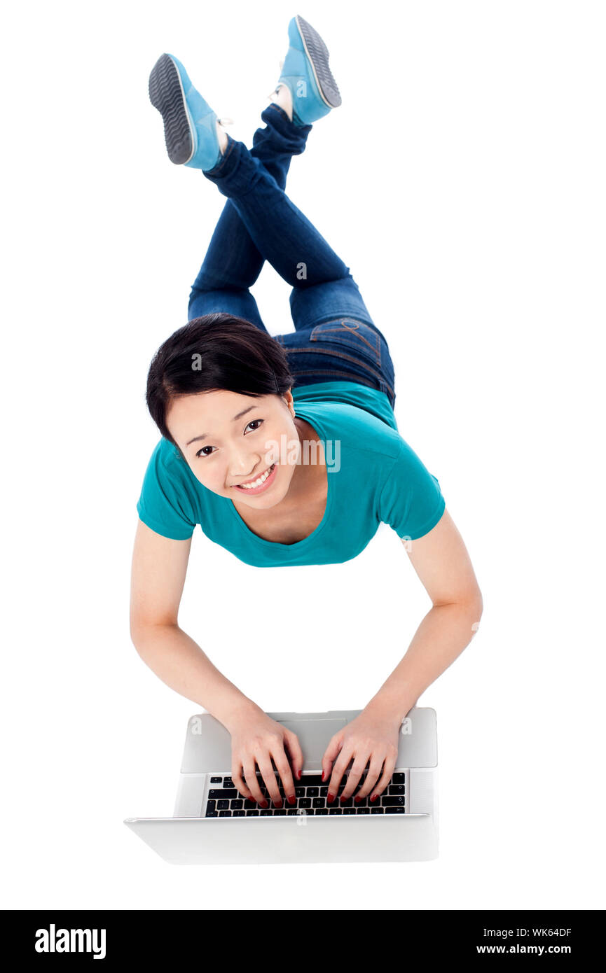 Smiling girl lying on the floor and using her laptop Stock Photo - Alamy