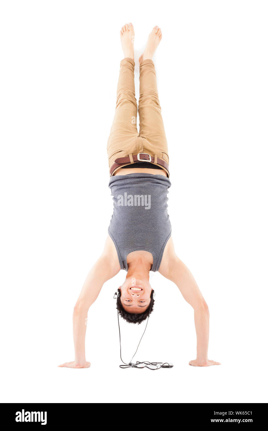 young man doing a handstand against and listening music Stock Photo