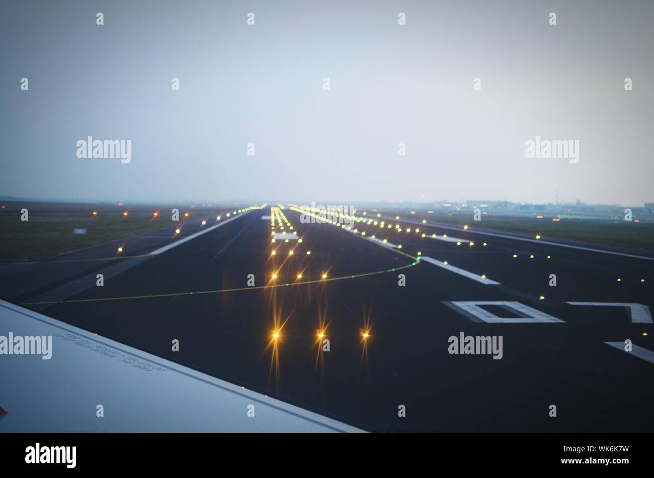 Cropped Image Of Airplane On Illuminated Airport Runway At Berlin Schonefeld Airport Stock Photo