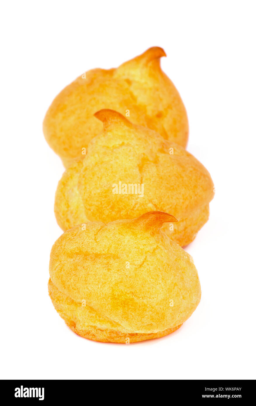 Three Freshly Baked Profiteroles In a Row isolated on white background Stock Photo