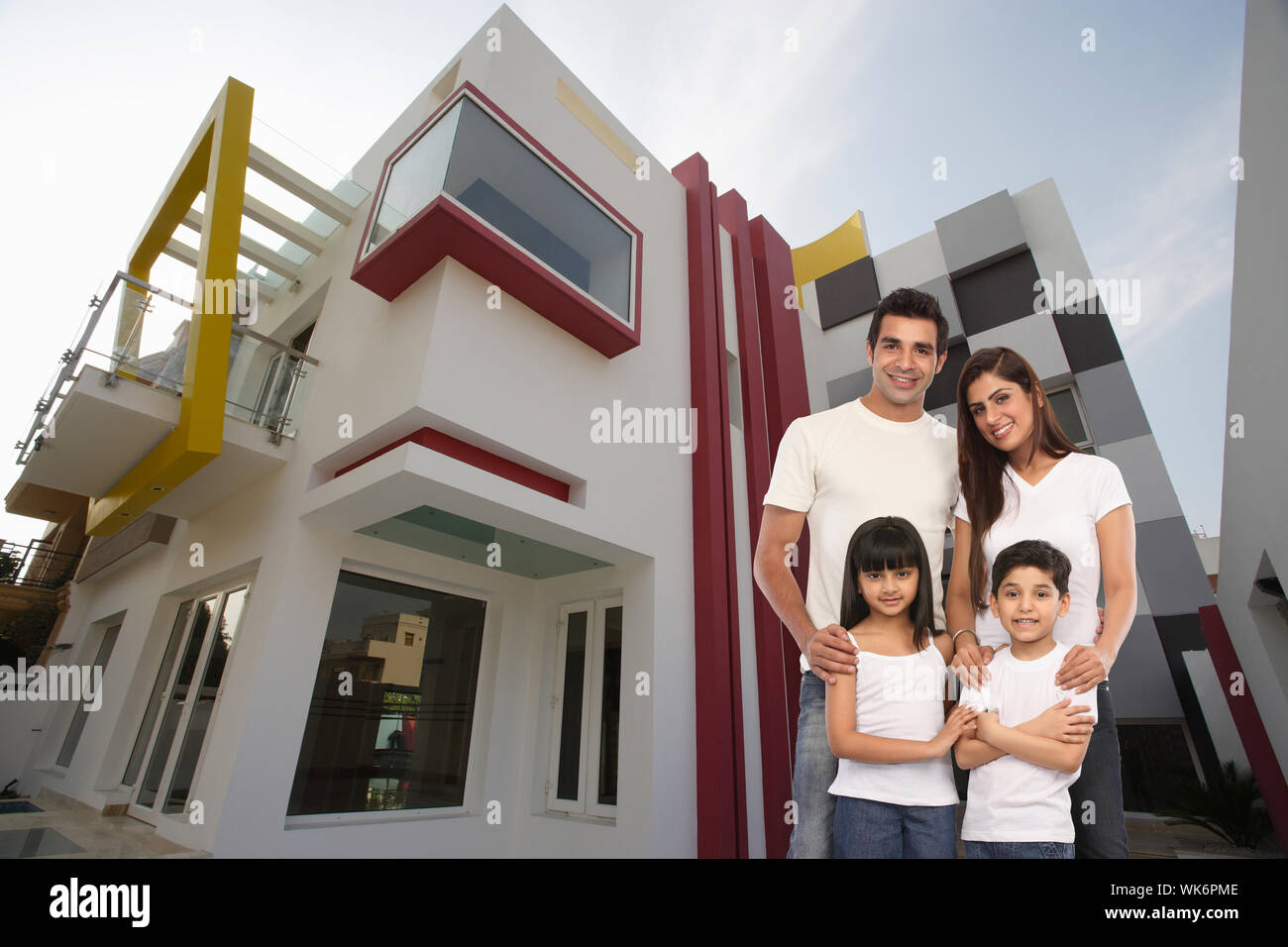 Family standing together in front of house Stock Photo - Alamy