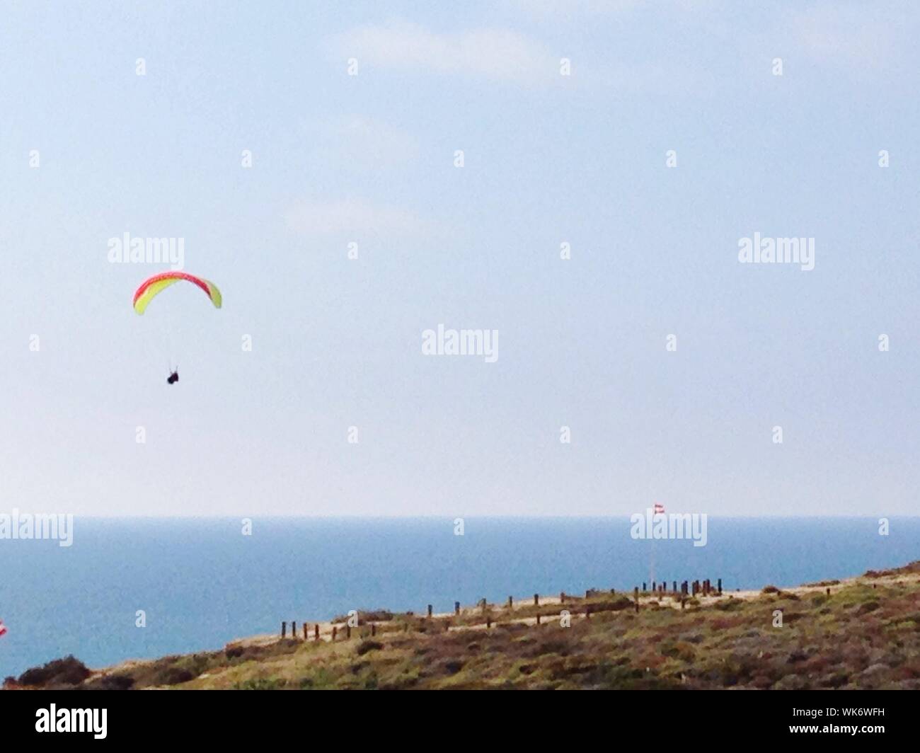 Person Paragliding Over Sea Stock Photo