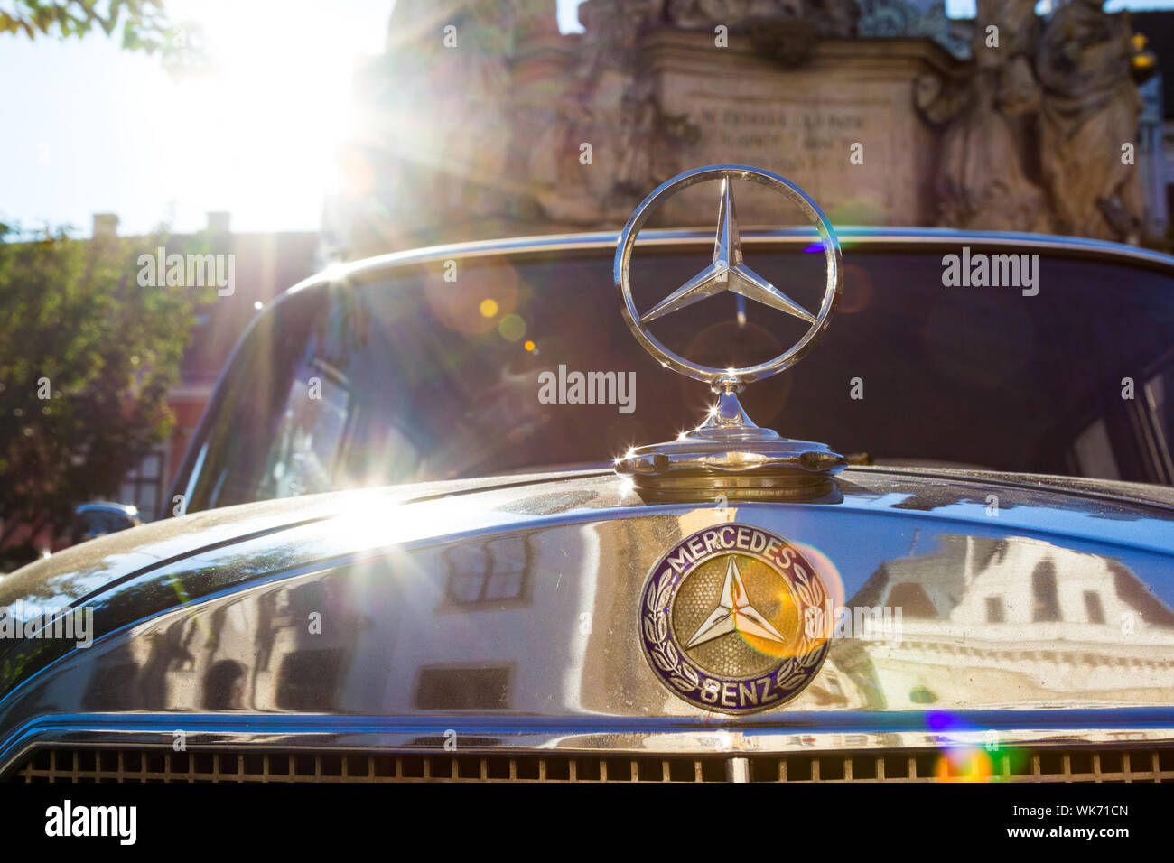 Retro vintage old Mercedes Benz emblem logo backlit with reflection of