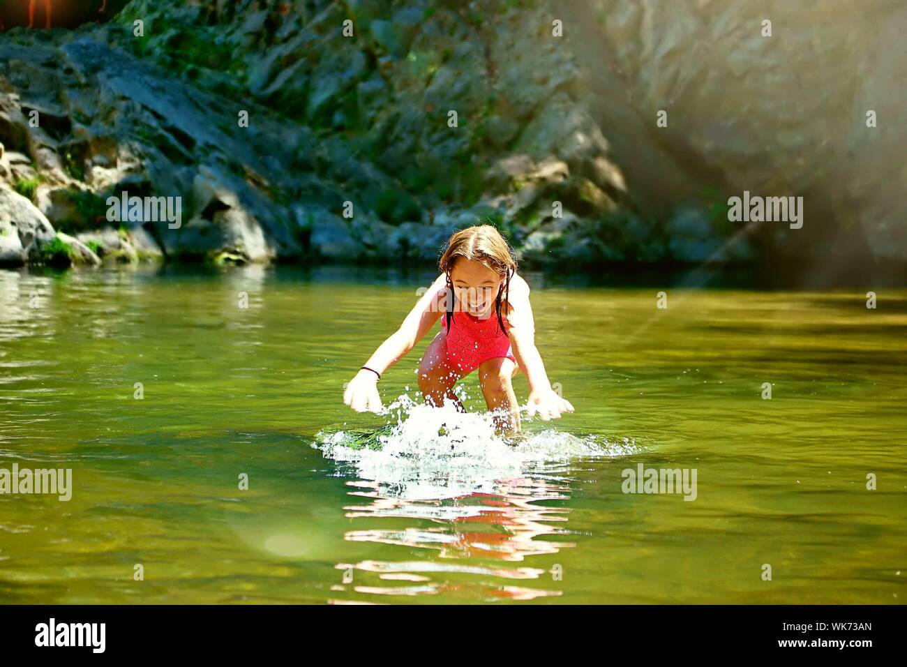 Cheerful Girl Playing In Lake At Big Basin Redwoods State Park Stock Photo
