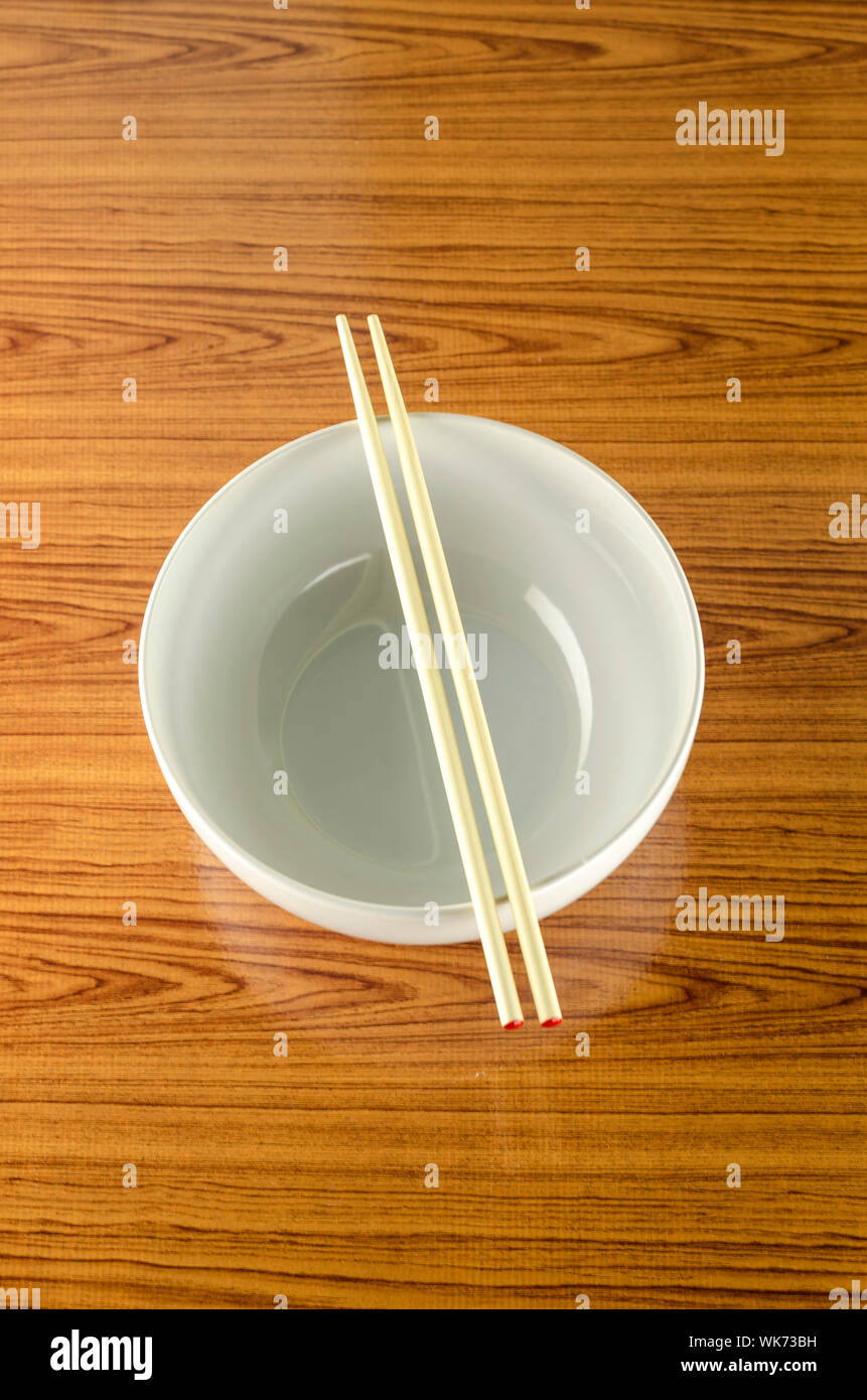 empty white bowl with chopstick on wood table background Stock Photo