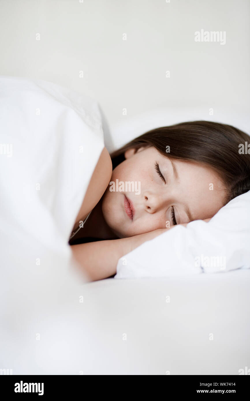 Little girl sleeping in bed cover with white blanket Stock Photo - Alamy
