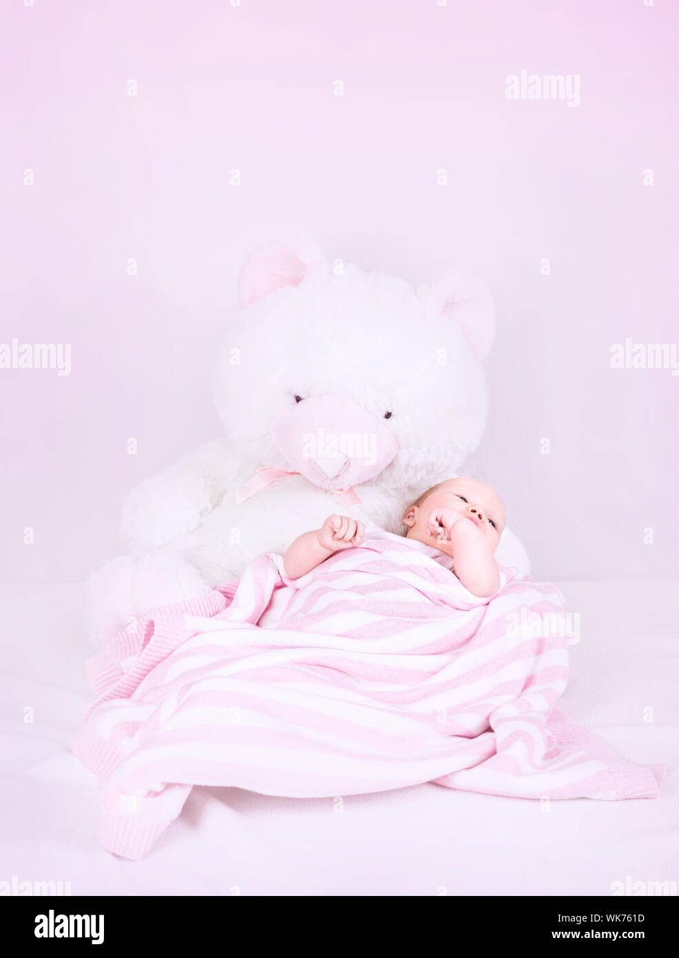 Cute Little Newborn Girl Lying Down On Big White Soft Bear
