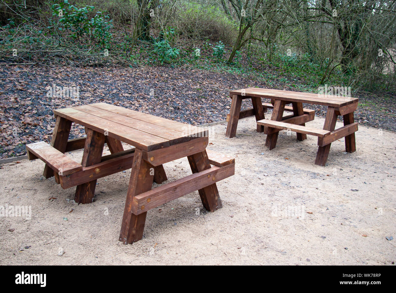 Two wooden picnic benches on a gravel base in a wood Stock Photo Alamy