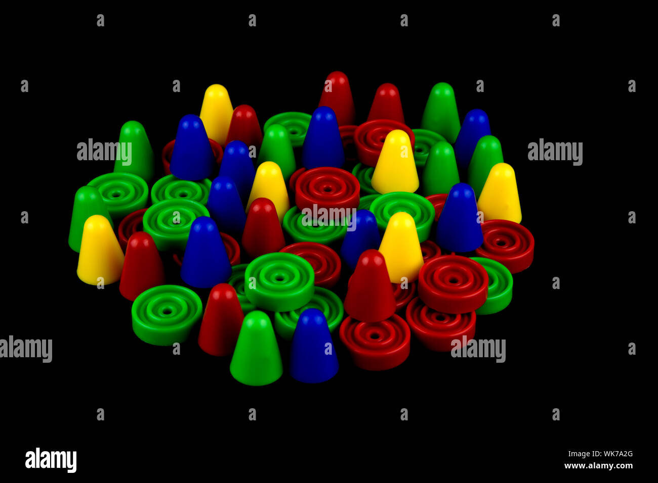 Coloured plastic board game tokens on a black background Stock Photo