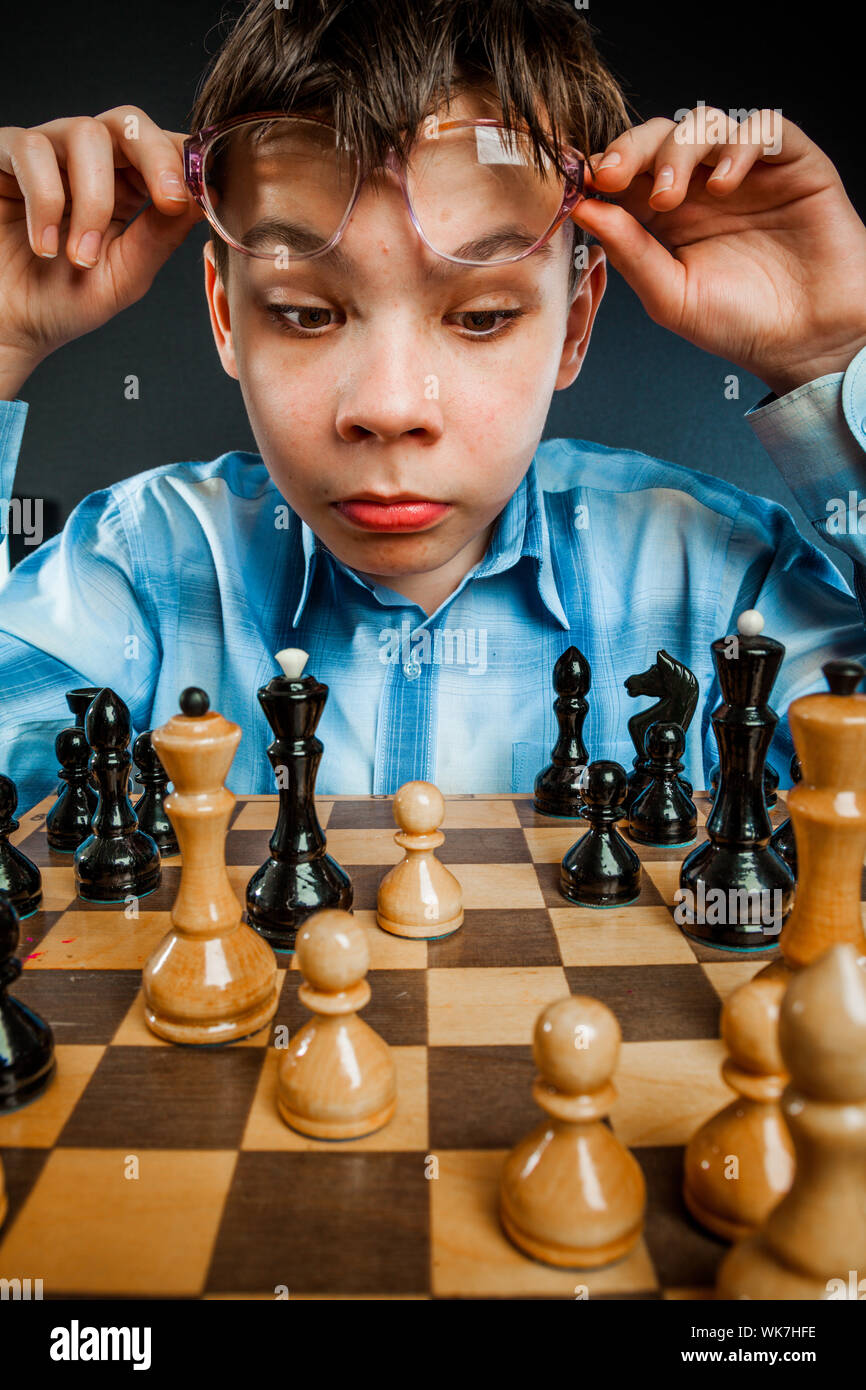 Wunderkind play chess. Funny Nerd boy. Stock Photo