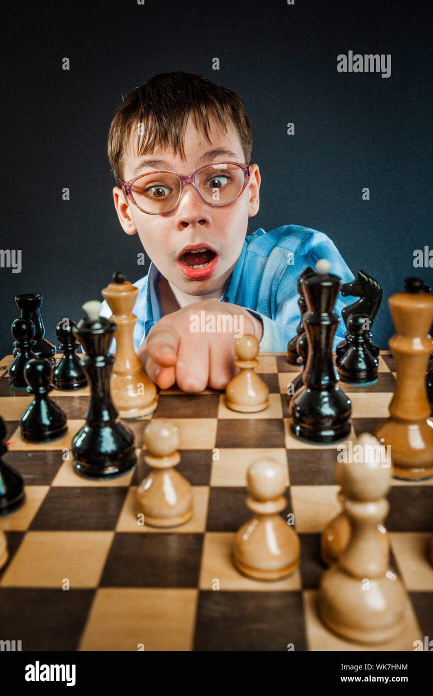 Wunderkind play chess. Funny Nerd boy. Stock Photo