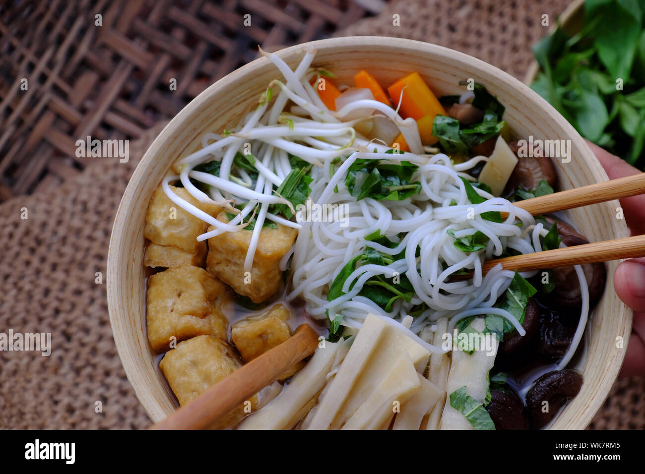 People eating breakfast, bun mang bowl, bamboo shoot noodles with tofu, mushroom, laksa leaves, herbs, an simple dish from vegetables but delicious Stock Photo