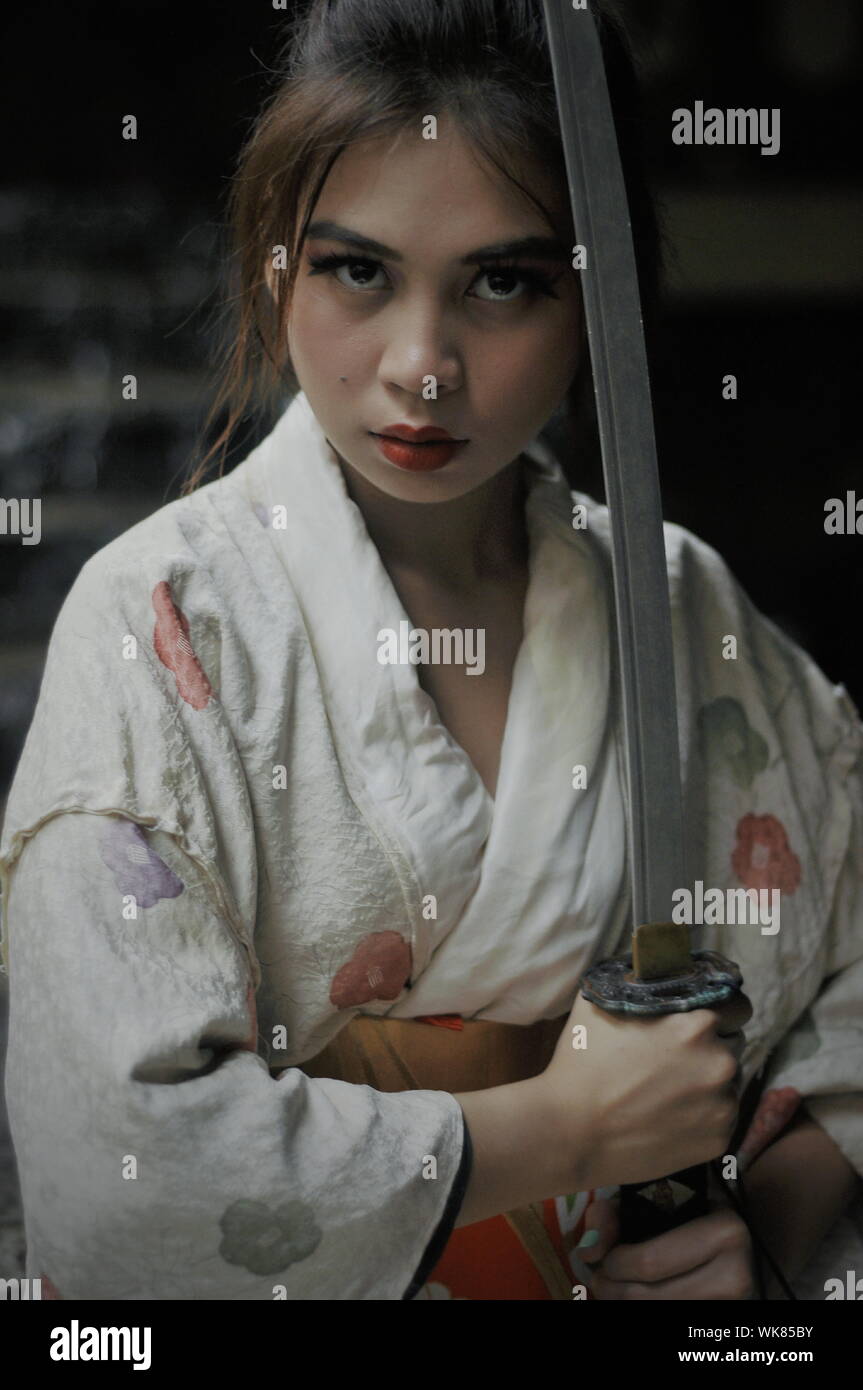 Portrait Of Young Woman Holding Sword Stock Photo