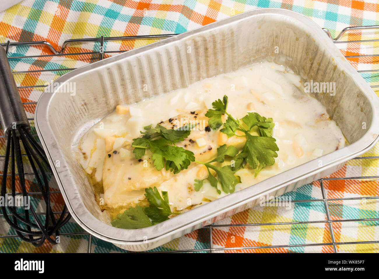 baked cod with parsley in a small aluminum bowl Stock Photo