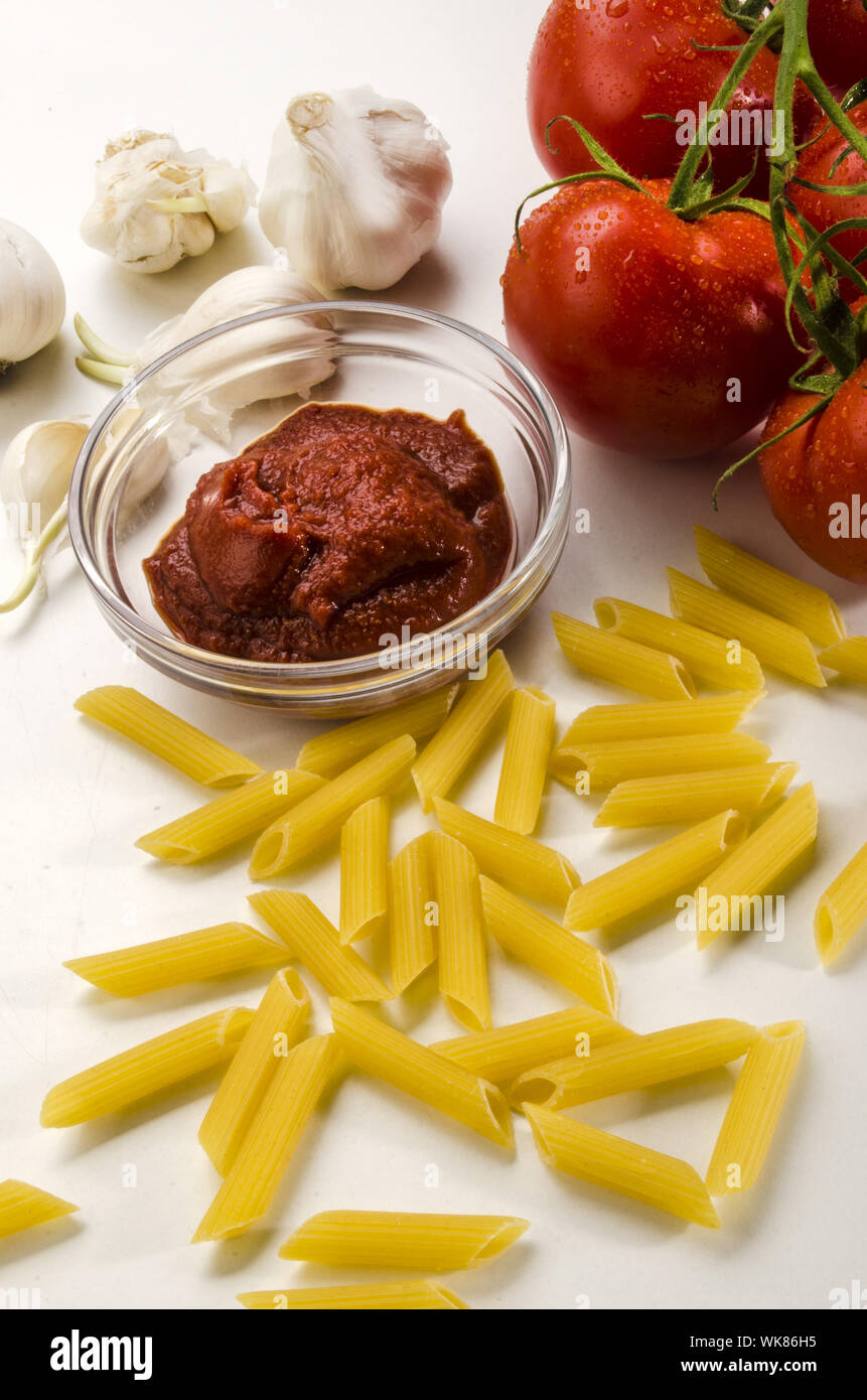 macaroni, tomato paste, garlic and fresh tomatoes to prepare an italian dish Stock Photo