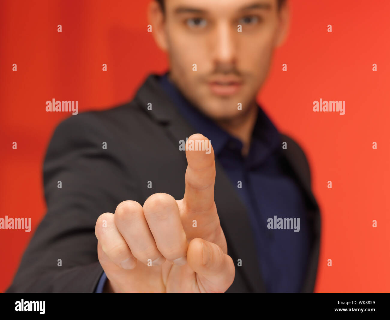 handsome man in suit pressing virtual button Stock Photo