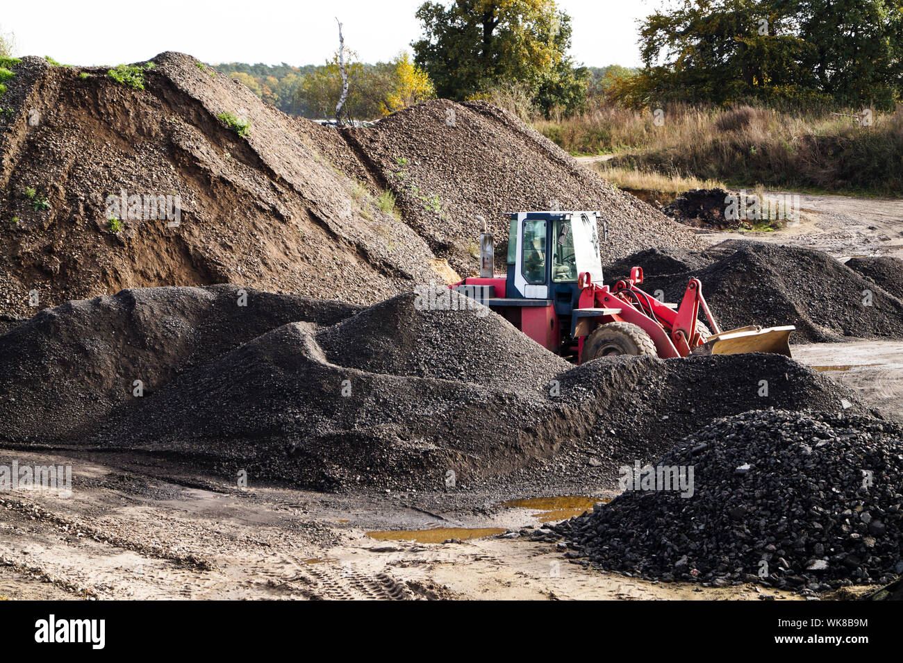 Tractor Amidst Sand Heaps In Coal Mine Stock Photo