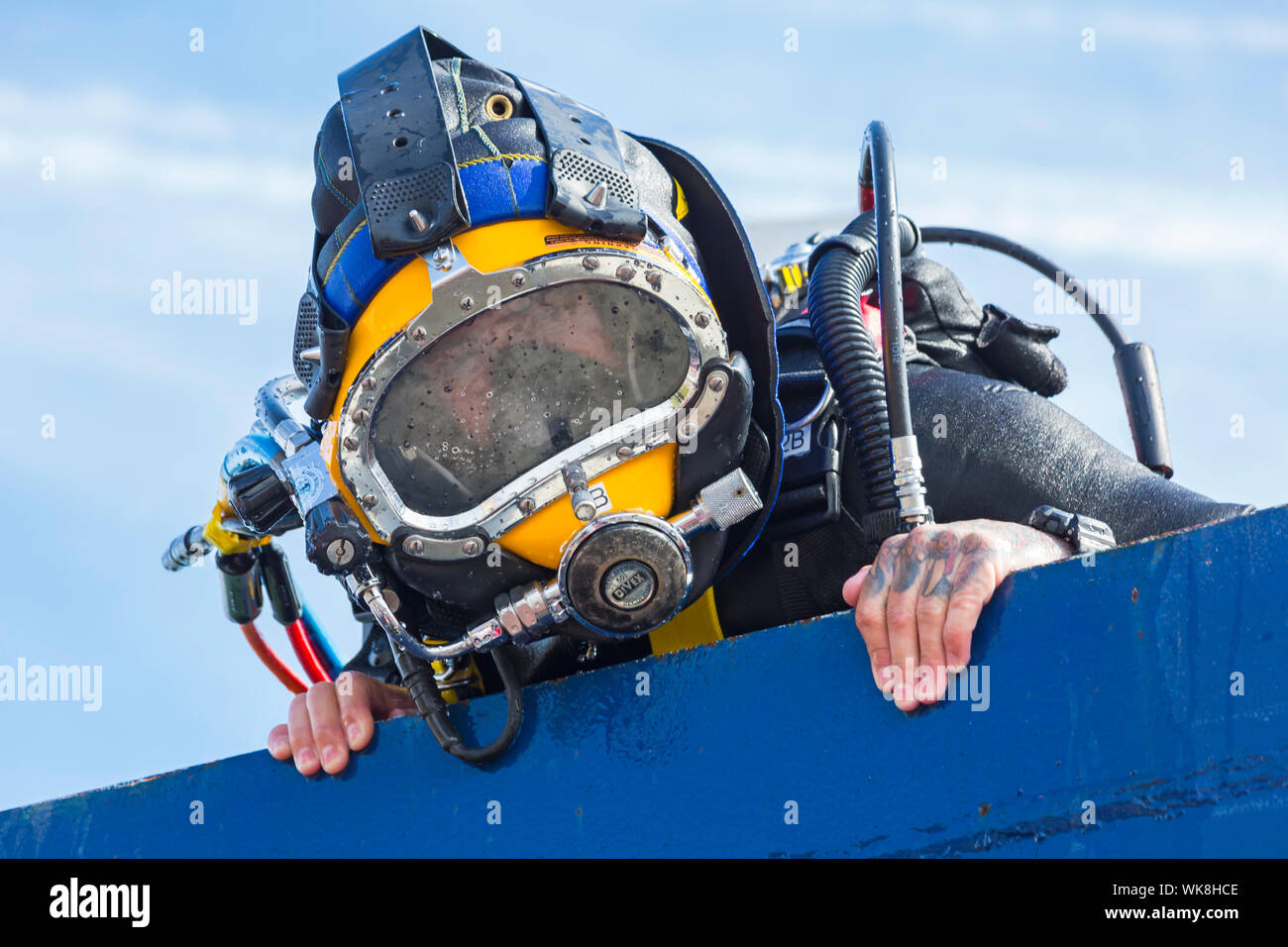 Diver looking up over top of dive tank, diving tank, at Bournemouth Air Festival, Dorset UK in August - diving helmet mask Stock Photo