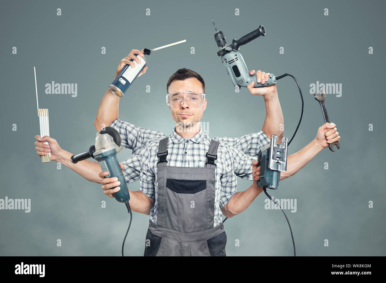 Funny portrait of a craftsman with 6 arms and tools Stock Photo