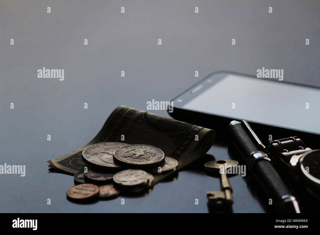 Still life of male cool belongings with dollar bills and coins Stock Photo - Alamy