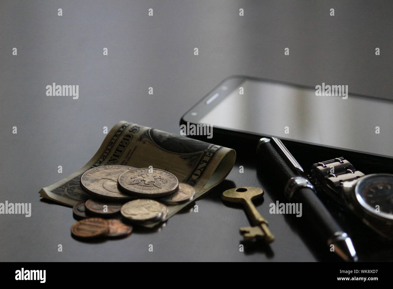 Still life of male cool belongings with dollar bills and coins Stock Photo