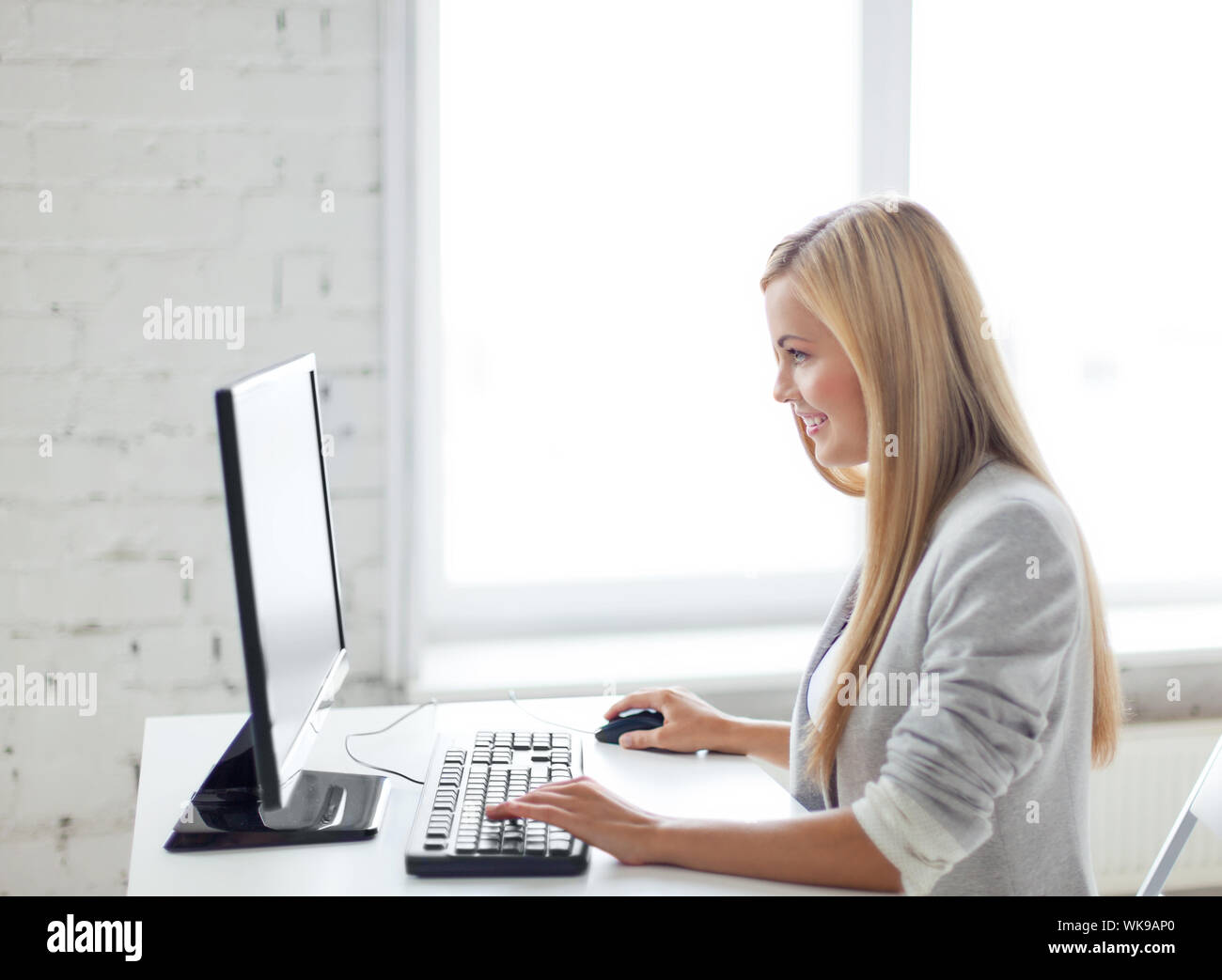 picture of smiling businesswoman with computer in office Stock Photo