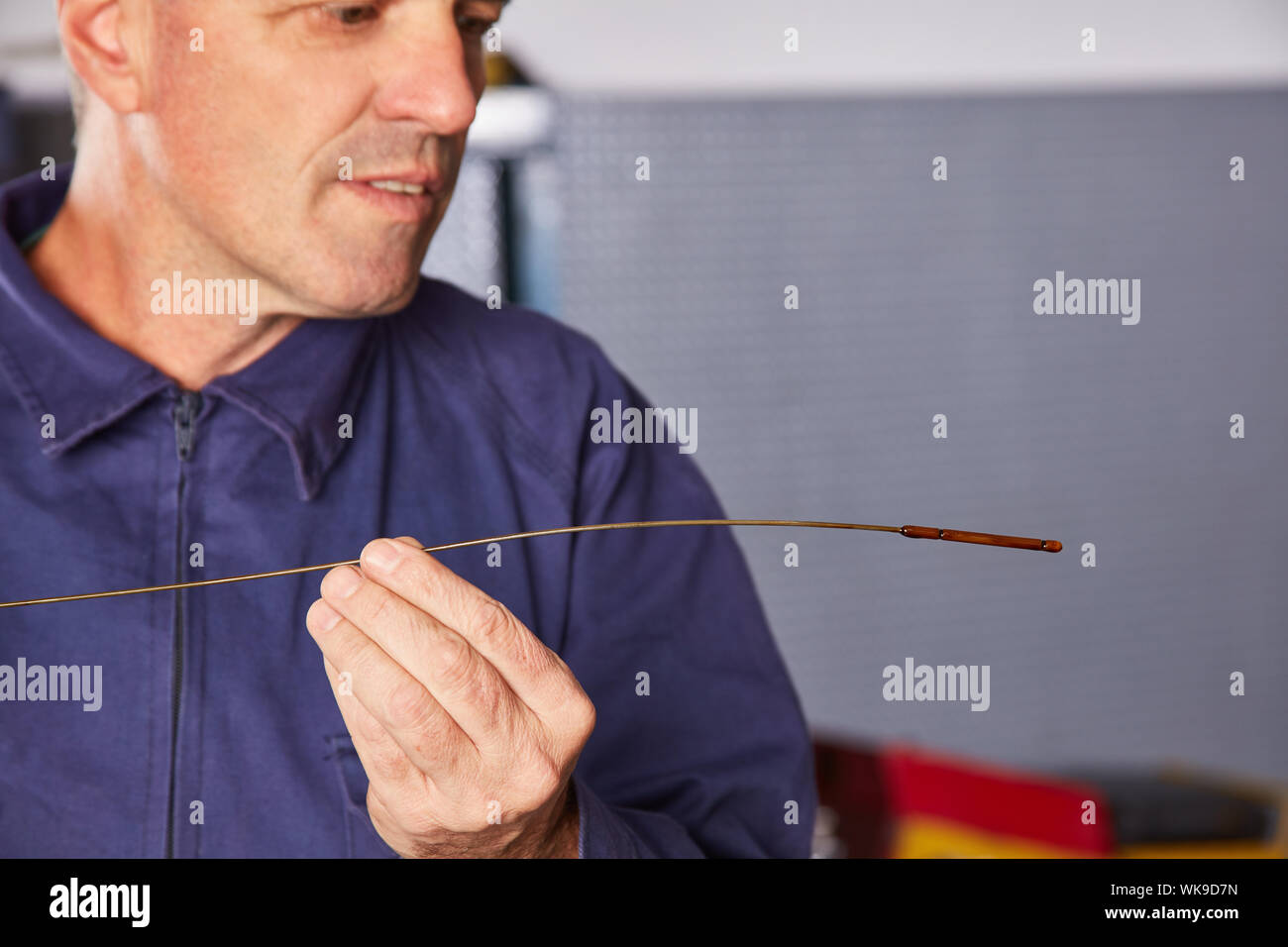 Automotive mechanic checking oil level with dipstick during inspection