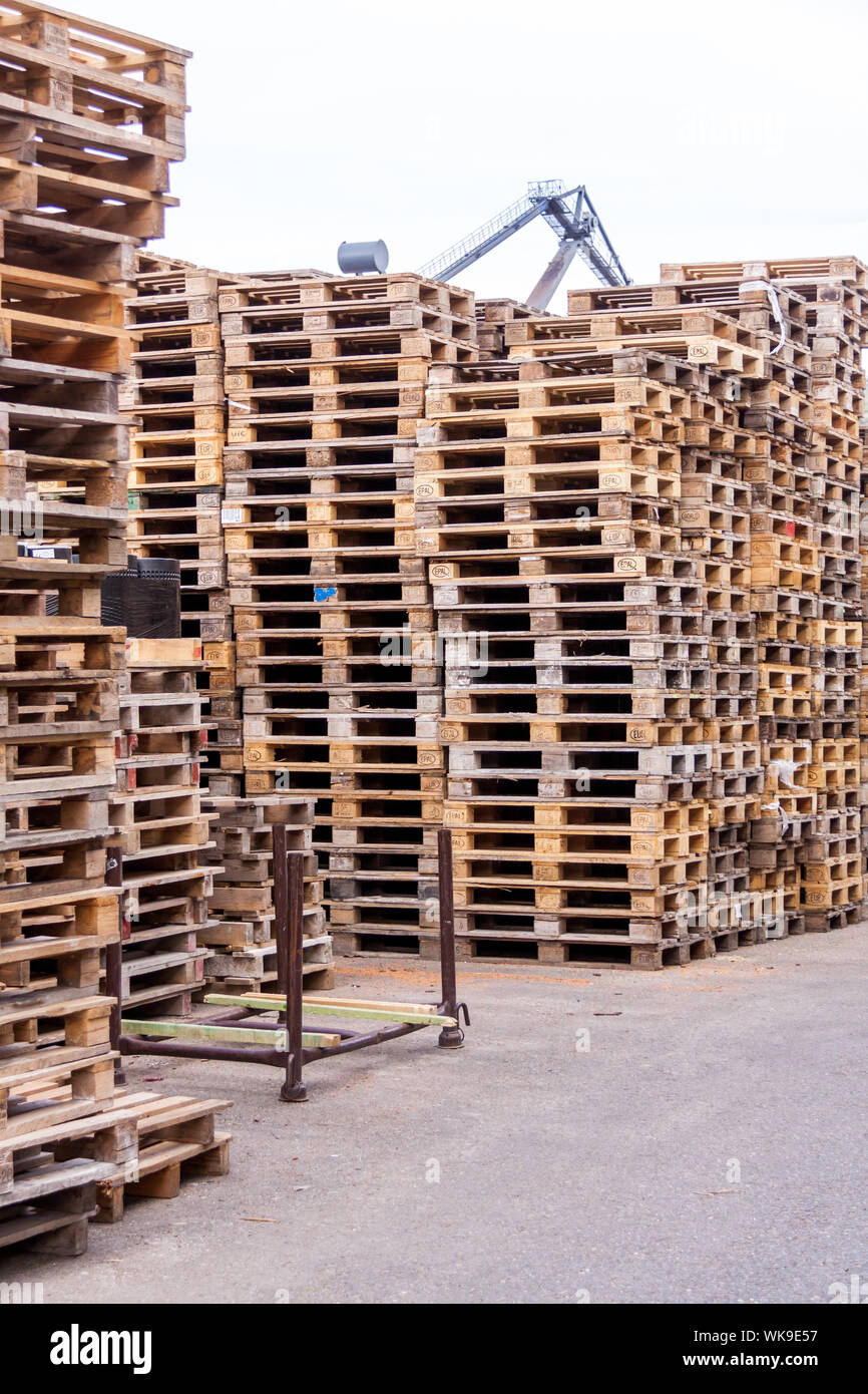 Stacks of old wooden pallets in a commercial or industrial yard used