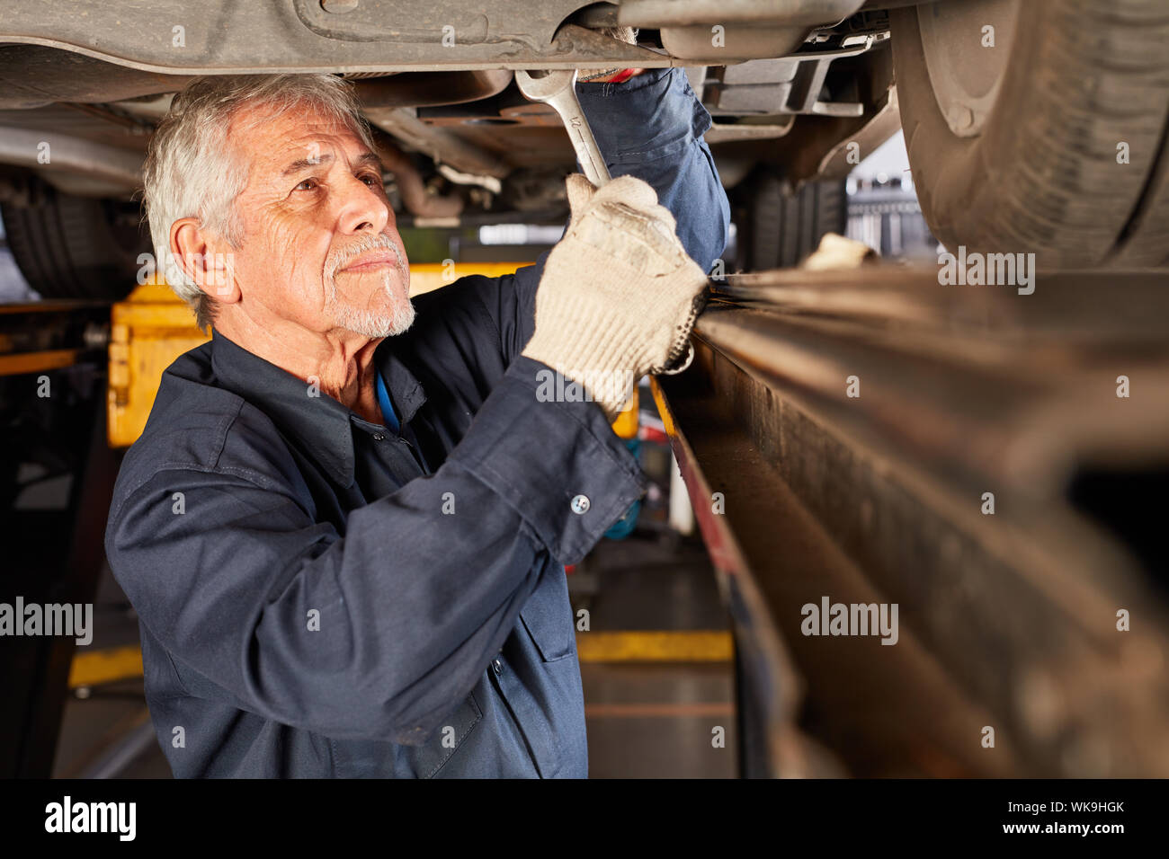 Senior as a car mechanic or mechatronic in the maintenance and inspection of car Stock Photo