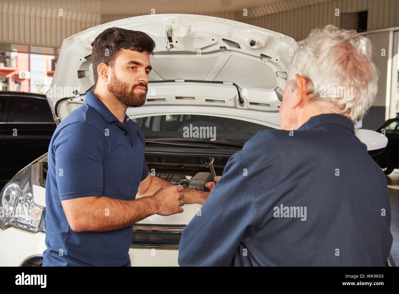 Two car mechatronics make an engine check during the inspection or maintenance Stock Photo