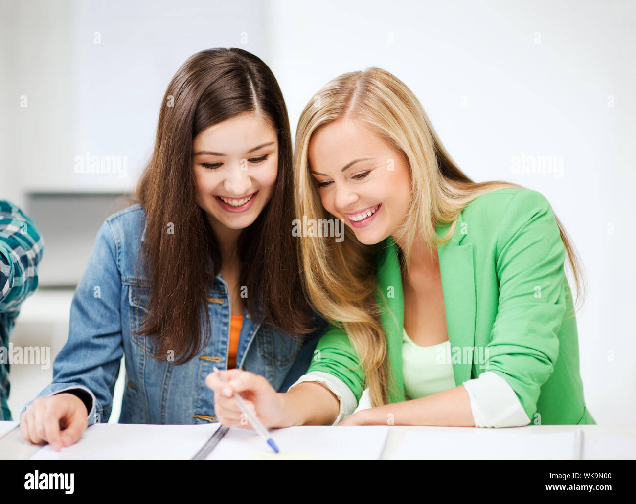 student girls pointing at notebook at school Stock Photo - Alamy