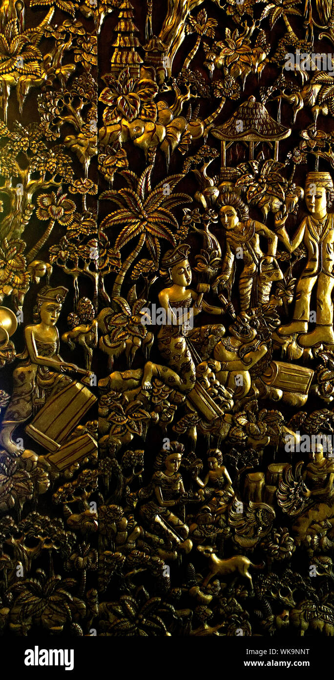 Scenes carved into a traditional Balinese wooden door and painted gold. Stock Photo