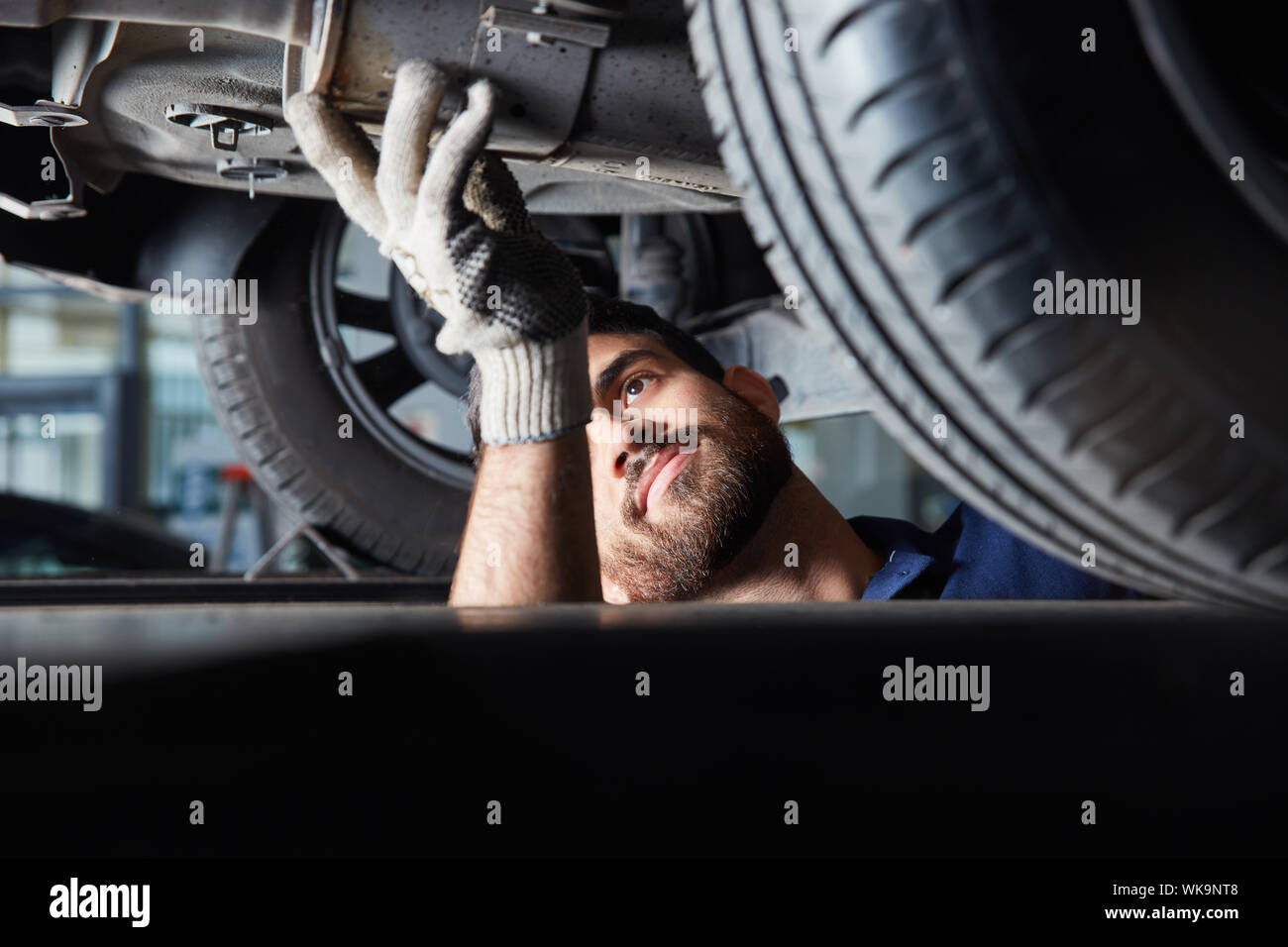 Mechatronics engineer or mechanic in the repair of car exhaust for main inspection Stock Photo