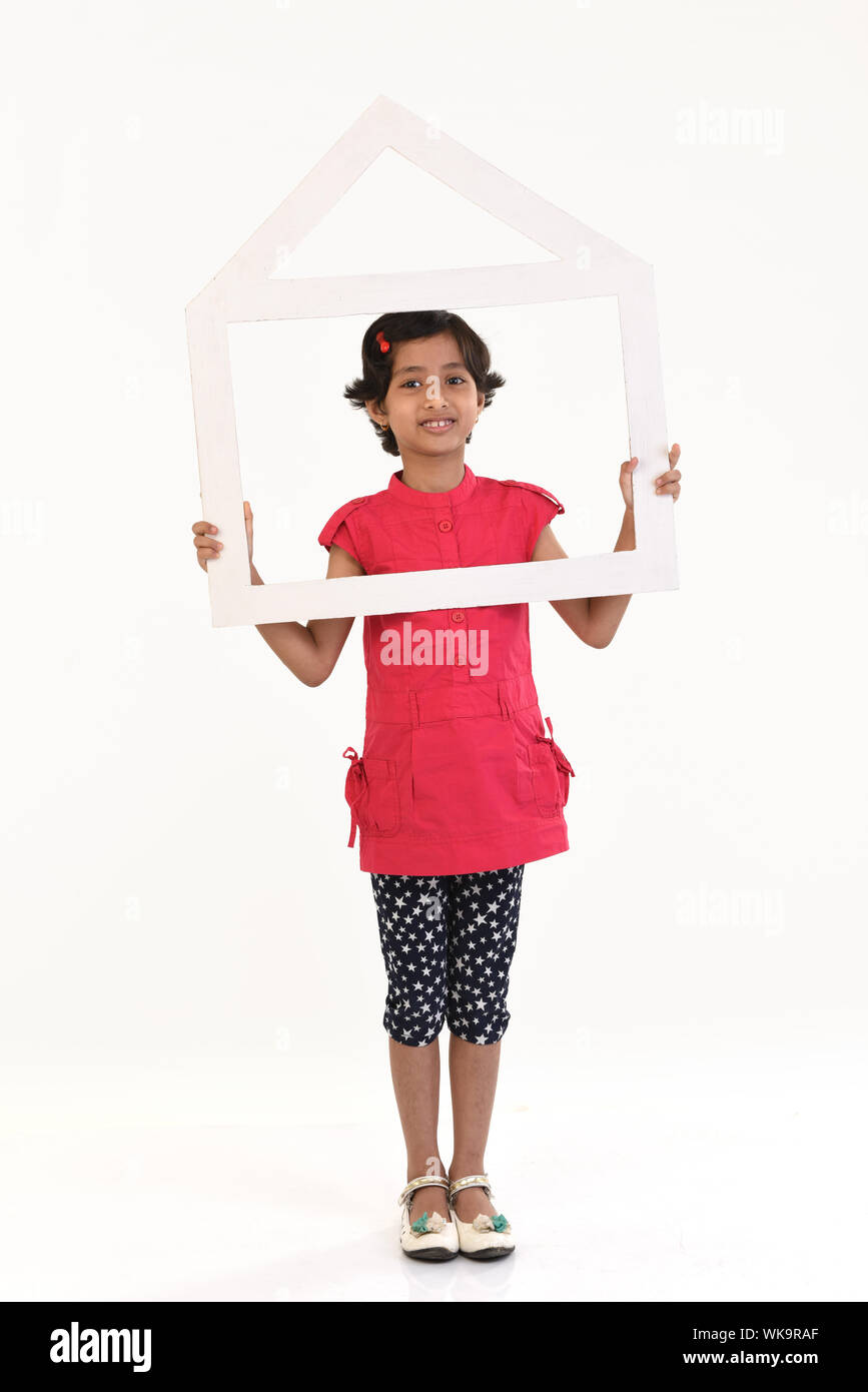 Girl holding a dream home shape frame Stock Photo