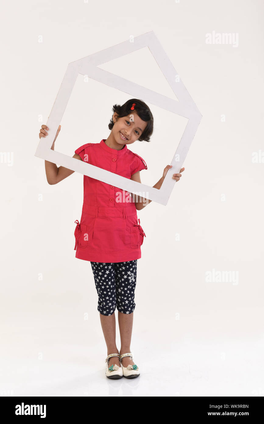 Girl holding a dream home shape frame Stock Photo