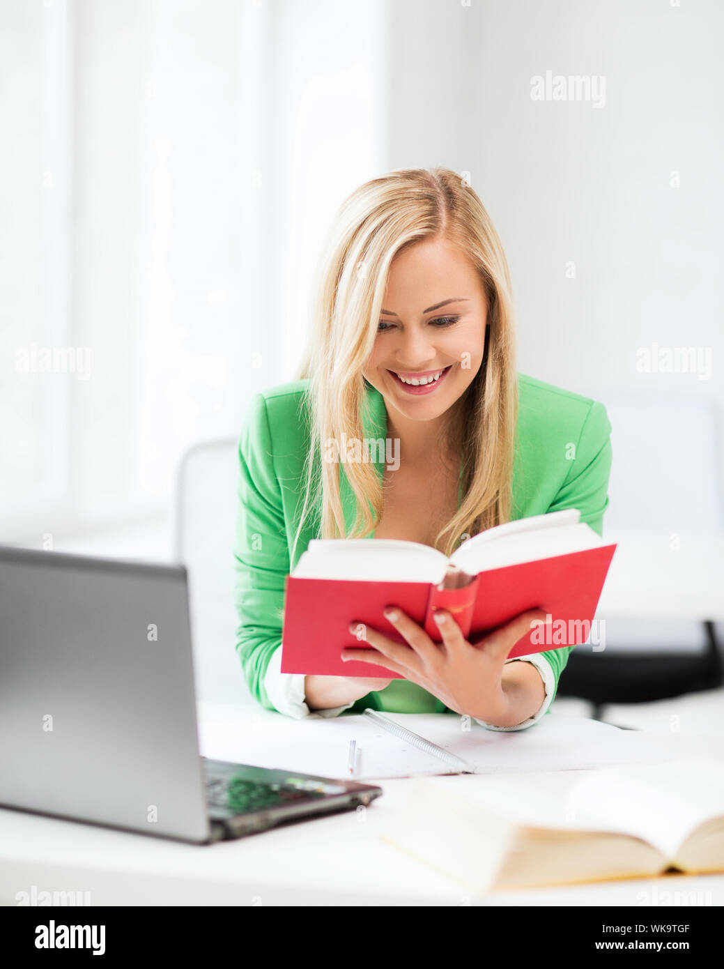 smiling student girl reading book in college Stock Photo - Alamy