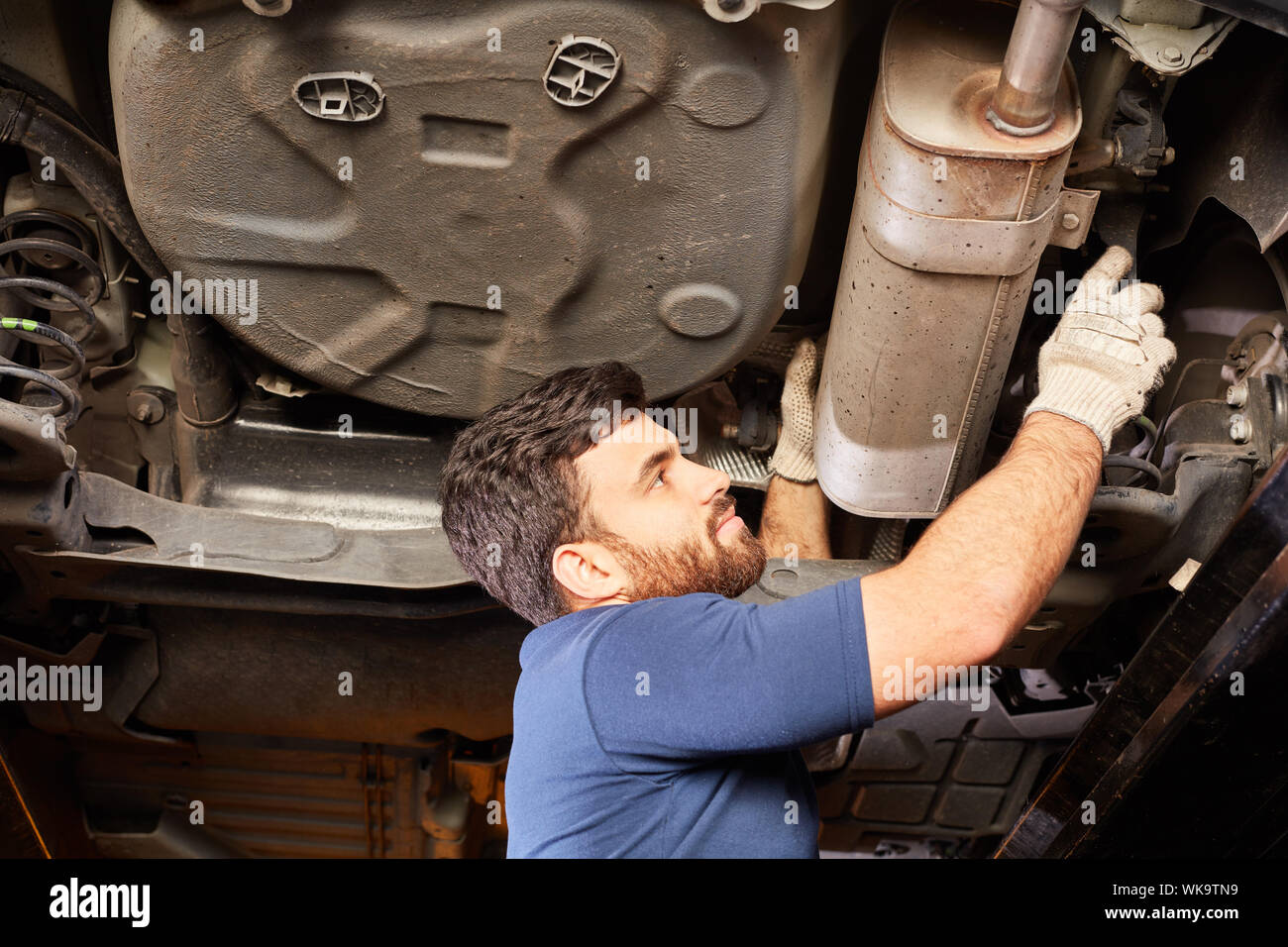 Automotive mechanic checks exhaust during exhaust emission inspection