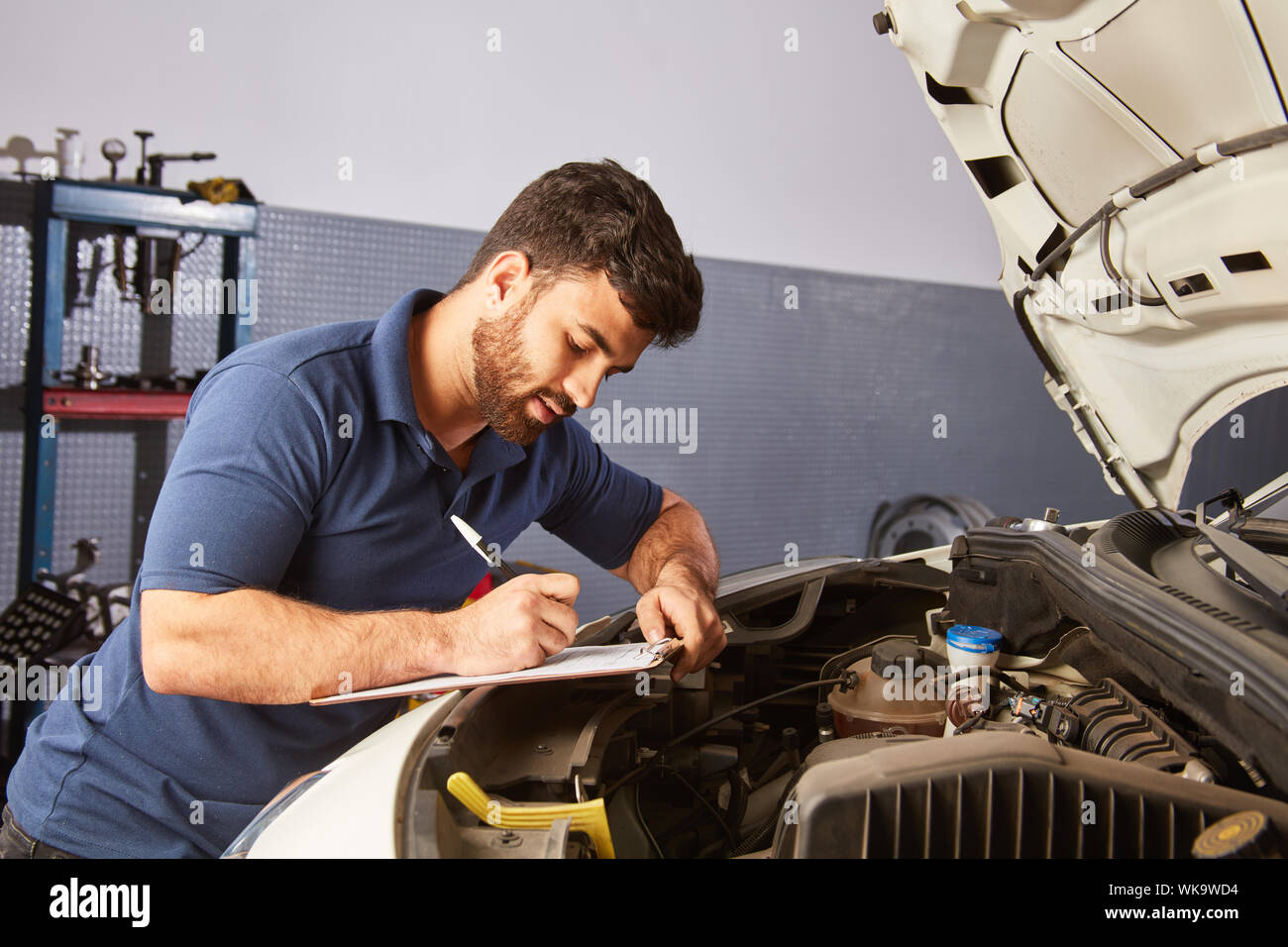 Car Mechatronics Engineer completes checklist for car inspection or ...