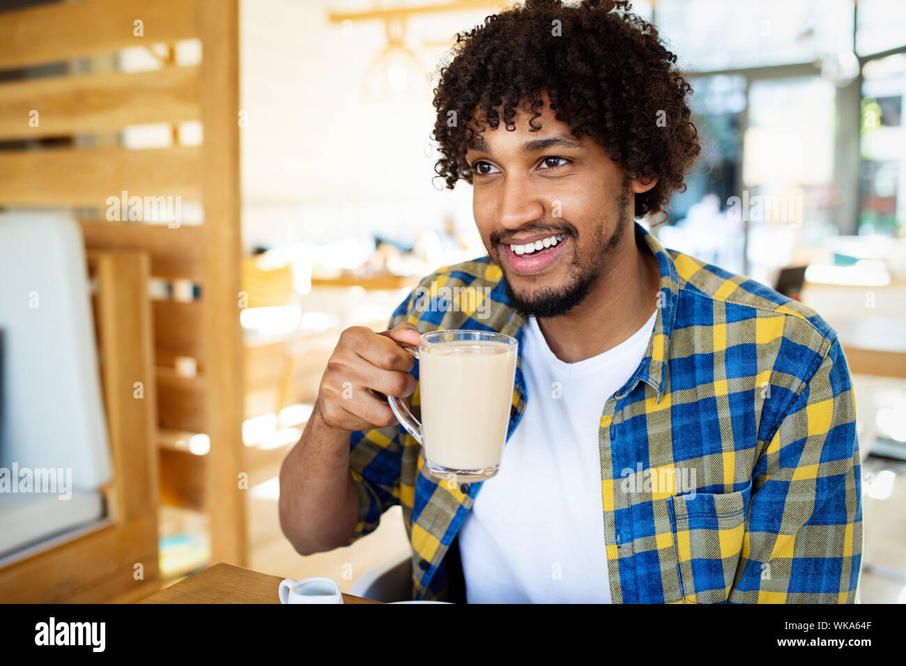Happy handsome black man drinking coffee and smiling Stock Photo