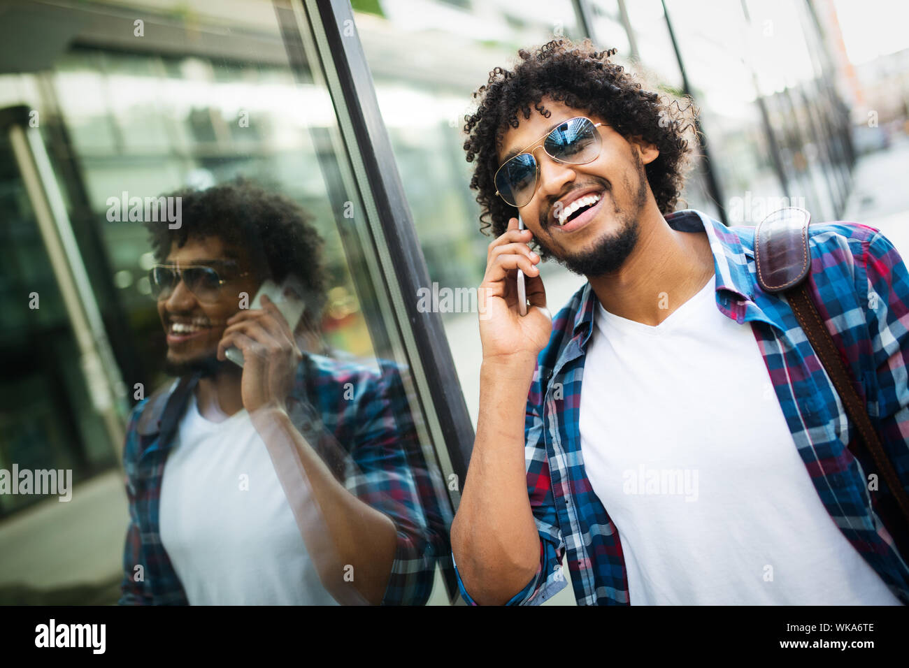 Happy afro man talking on the phone while walking Stock Photo